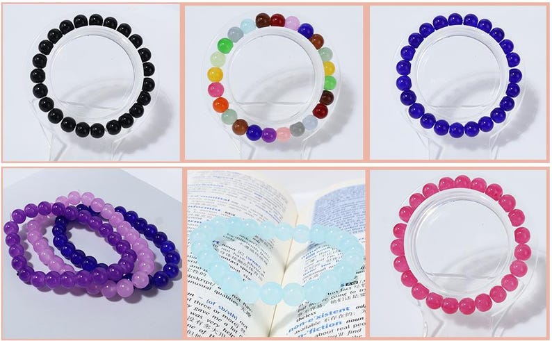 May include: A collection of beaded bracelets in various colors, including black, rainbow, blue, purple, and pink. The bracelets are displayed on clear stands, showcasing the round beads. Some bracelets are stacked together.