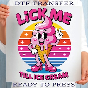 May include: A DTF transfer featuring a cartoon ice cream cone with pink ice cream, wearing pink high heels, and giving a peace sign. The text "LICK ME" and "TILL ICE CREAM" are above and below the ice cream, with "READY TO PRESS" at the bottom.