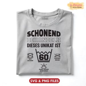 May include: A light gray t-shirt with black text and care symbols. The text reads "SCHONEND BEHANDELN DIESES UNIKAT IST" with washing instructions including a 60-degree wash symbol. The shirt also has the text "SVG & PNG FILES".