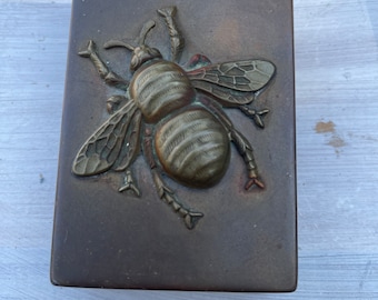 Antique metal box with a giant bee
