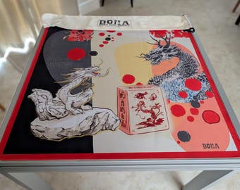 May include: A square playmat featuring a black and white yin-yang inspired background with red circular accents. The design includes two detailed dragon illustrations, a red rectangular box graphic with Asian characters, and the text DONA at the top and bottom.