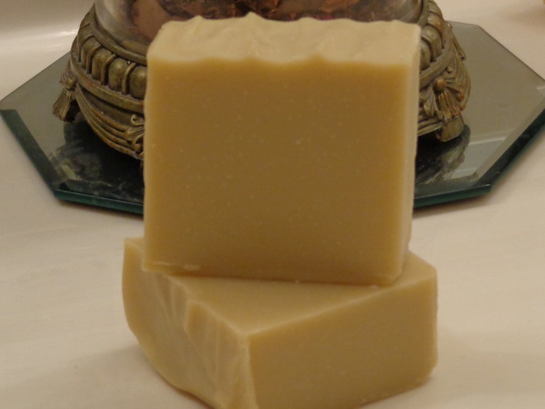 Pu&ograve; includere: Due saponette fatte a mano, una sopra l'altra. Il sapone &egrave; di colore beige chiaro e ha una superficie liscia leggermente ruvida.