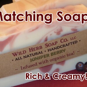 以下が含まれることがあります： ブラウンの紙ラベルに「WILD HERB SOAP CO. LLC &bull; ALL NATURAL &bull; HANDCRAFTED. JUNIPER BERRY ~ Infused with organic tea! ~ Rich & Creamy!」と書かれた、手作り石鹸2個