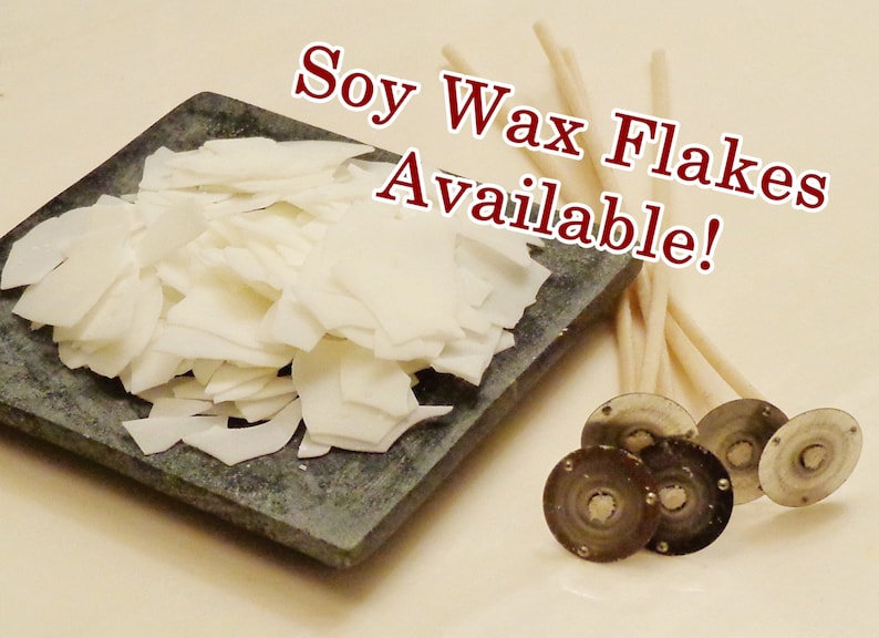 Pode incluir: Flocos de cera de soja brancos sobre uma superf&iacute;cie de pedra cinza, ao lado de um pacote de pavios de vela brancos e quatro adesivos de pavios de vela prateados. O texto "Soy Wax Flakes Available!" est&aacute; escrito em letras vermelhas sobre fundo branco.