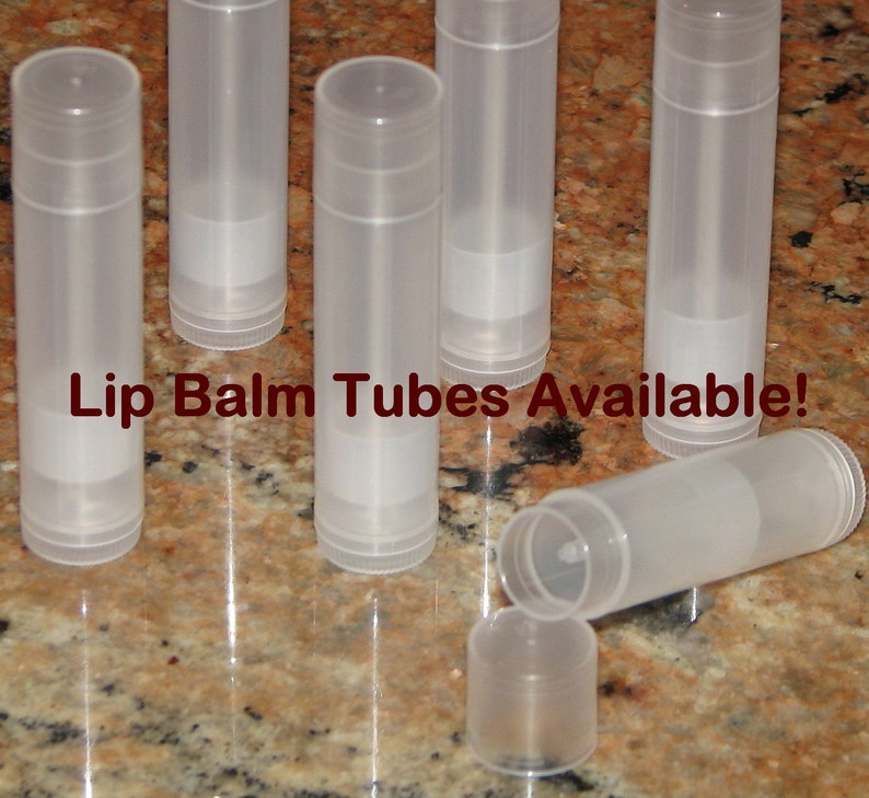 May include: A group of eight clear plastic lip balm tubes. The tubes are empty and ready to be filled with lip balm. The text "Lip Balm Tubes Available!" is printed on the table surface.