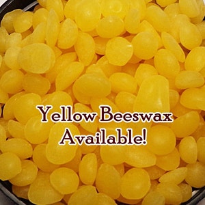 May include: A close-up image of yellow beeswax pellets. The text "Yellow Beeswax Available!" is superimposed on the image.