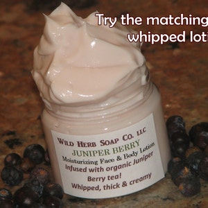May include: A jar of Juniper Berry moisturizing face and body lotion with a whipped, creamy texture. The label reads "Wild Herb Soap Co. LLC" and "Berry tea!" with a pile of dark berries.