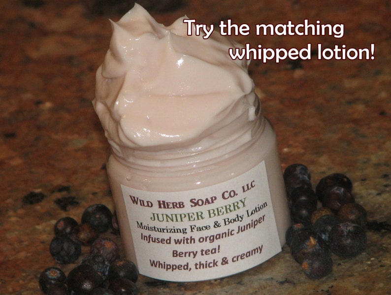 May include: A jar of Juniper Berry moisturizing face and body lotion with a whipped, creamy texture. The label reads "Wild Herb Soap Co. LLC" and "Berry tea!" with a pile of dark berries.