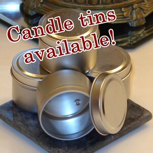 May include: A group of five silver metal candle tins, stacked on top of each other. The text "Candle tins available!" is written in red letters across the top of the image.