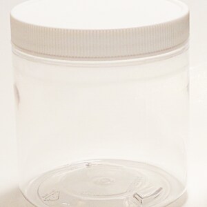 May include: A clear plastic jar with a white lid. The jar is empty and has a smooth, rounded bottom.