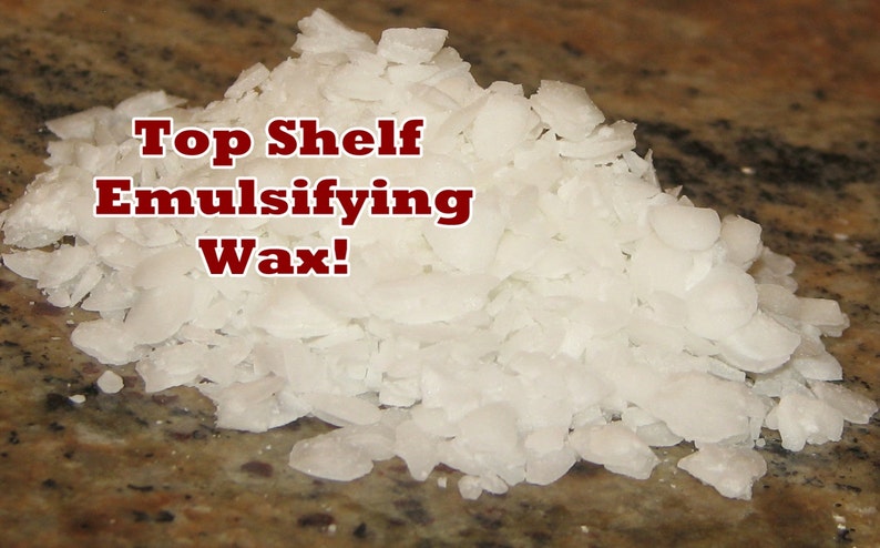 May include: A close-up of white, flaked emulsifying wax. The text "Top Shelf Emulsifying Wax!" is written in red letters on top of the wax.