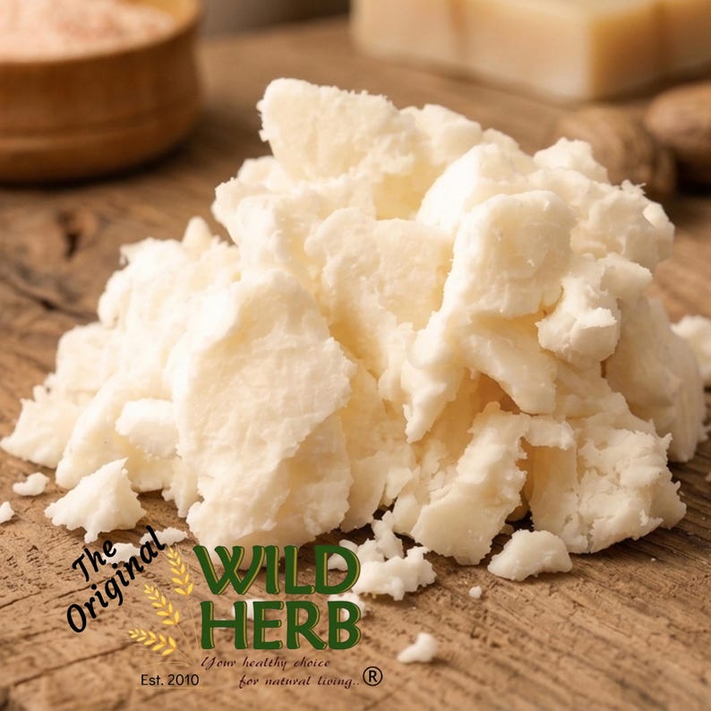May include: A close-up of a pile of off-white shea butter chunks on a wooden surface. The Wild Herb logo is visible, along with the text "The Original" and "Your healthy choice for natural living."