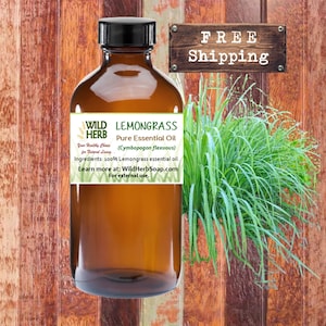 May include: A brown glass bottle with a label that reads "WILD HERB LEMONGRASS Pure Essential Oil (Cymbopogon flexuous) Your Healthy Choice for Natural Living Ingredients: 100% Lemongrass essential oil. Learn more at: WildHerbSoap.com For external use." The bottle is sitting on a wooden surface. A green plant is in the background.