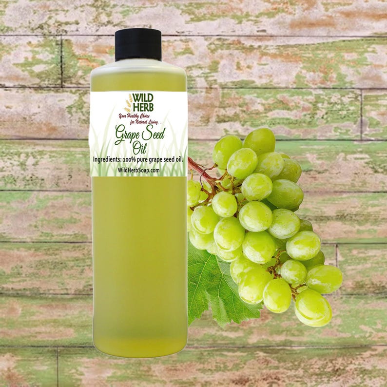 May include: A clear bottle of Wild Herb Grape Seed Oil with a black cap, a white label, and a bunch of green grapes. The label reads "Grape Seed Oil" and "Ingredients: 100% pure grape seed oil."
