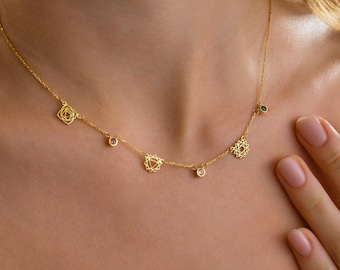 May include: A delicate gold necklace featuring geometric charms and small gemstones. The necklace has a fine chain and is adorned with various shapes and sparkling accents. The design is elegant and minimalist, suitable for everyday wear.