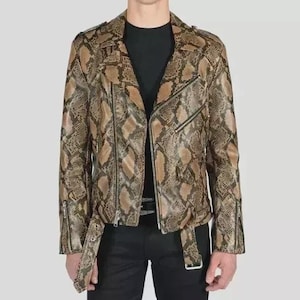 Puede incluir: Chaqueta de cuero marrón y beige con estampado de piel de serpiente, de estilo motero clásico. La chaqueta presenta un cuello con solapas, cierre de cremallera asimétrico y bolsillos con cremallera. Tiene cinturón en la cintura y cremalleras en los puños.