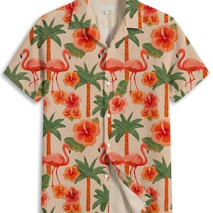 May include: Short-sleeved button-down shirt with a tropical pattern. The shirt features a repeating design of pink flamingos, orange hibiscus flowers, and green palm trees on a beige background. The shirt has a classic collar and a button-up front.