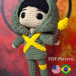 May include: Crocheted doll wearing a green hooded outfit with a yellow cross design and brown boots, holding a yellow torch. The doll has black hair and large black eyes. Text on the image reads "PDF Pattern".