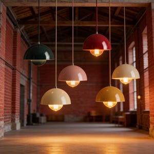 Peut inclure: Plusieurs lampes suspendues en forme de dôme, de couleurs variées : vert foncé, rose, rouge, jaune et crème. Chaque lampe est équipée d'une ampoule visible. Elles sont suspendues dans une pièce aux murs en briques.
