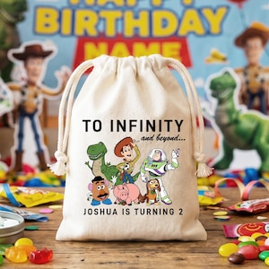 Könnte beinhalten: Ein beiger Kordelzugbeutel mit der Aufschrift "TO INFINITY and beyond..." und "JOSHUA IS TURNING 2". Der Beutel zeigt eine farbenfrohe Grafik von Toy Story-Charakteren. Im Hintergrund befinden sich ein Geburtstagsbanner und Partygeschenke.
