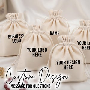 Może przedstawiać: Kolekcja beżowych torebek ze sznurkiem i czarnym tekstem. Torby są oznaczone frazami takimi jak "BUSINESS LOGO", "YOUR LOGO HERE" i "YOUR DESIGN HERE". Widoczne są r&oacute;wnież słowa "Custom Design" i "MESSAGE FOR QUESTIONS".