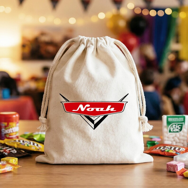 May include: A natural-colored canvas drawstring bag featuring a red, white, and black graphic logo on the front. The logo is shaped like a stylized emblem with the name Noah printed in white letters across the center of the red section.
