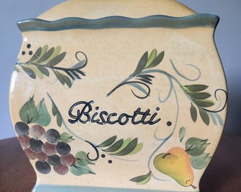 Pote de biscoitos vintage de cerâmica Nonni's Biscotti, retangular, bege, amarelo e verde, com estampa de frutas e vinhas da Toscana: uva, pera e morango.