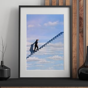 May include: Framed art print featuring a surreal image of a person ascending a staircase that leads into the sky. The artwork is set against a backdrop of a blue sky with fluffy white clouds. The frame is black.
