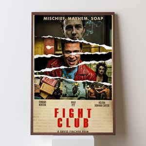 Puede incluir: Un póster enmarcado de la película "Fight Club" con un borde marrón. El póster presenta imágenes de los actores Brad Pitt, Edward Norton y Helena Bonham Carter. El título "FIGHT CLUB" está en letras rojas grandes.