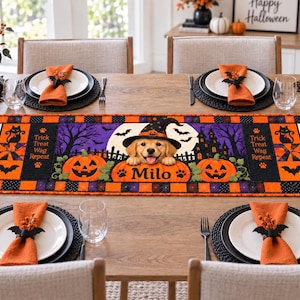 May include: A rectangular Halloween table runner featuring a golden retriever puppy wearing a witch hat, centred between two jack-o'-lanterns. The design includes the text "Trick Treat Wag Repeat" and "Milo" on a purple and orange background.