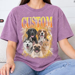 Puede incluir: Una camiseta morada con lavado mineral que presenta la palabra CUSTOM en letras con degradado naranja y amarillo sobre un gráfico de cinco animales, incluyendo un Labrador negro, un beagle, un husky, un bulldog francés y un gato atigrado naranja.
