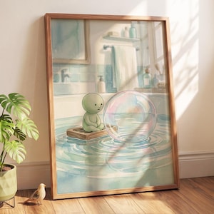 May include: A framed wall art print depicting a small, round, light green character sitting on a wooden raft in a bathtub. Beside the character is a large, iridescent soap bubble floating on the water. The bathroom background features blue tiles.