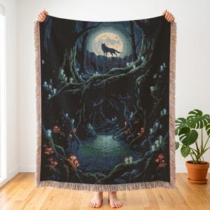 Peut inclure: Un plaid tissé représentant une scène de forêt sombre avec un loup debout sur une falaise sous une pleine lune. Le motif comprend des champignons lumineux, des branches d'arbres entrelacées et un petit étang, avec des bords à franges.