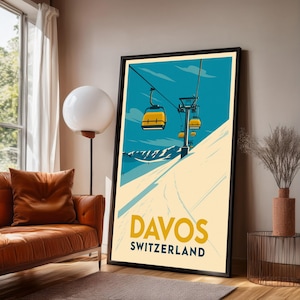 May include: A framed poster featuring a vintage ski resort advertisement. The poster has a blue sky background with yellow ski lift cars ascending a snowy mountain. The text "DAVOS SWITZERLAND" is displayed in yellow and navy blue.