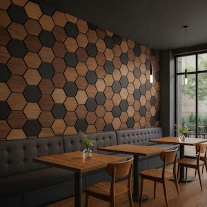 Könnte beinhalten: Innenraum eines Restaurants mit einer Wand, die mit sechseckigen Holz- und schwarzen Fliesen verziert ist. Der Raum verfügt über Holztische, Stühle und eine eingebaute Bank mit dunkelgrauer Polsterung. Hängelampen beleuchten den Raum.