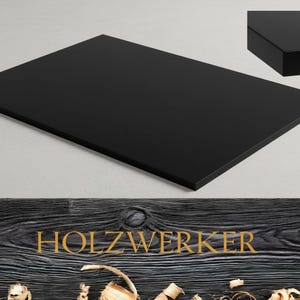May include: A rectangular, black wooden tabletop with a glossy finish. The image includes a close-up of the edge, showcasing the thickness. The word "HOLZWERKER" is displayed in gold lettering on a wood grain background.