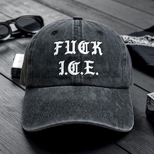 Puede incluir: Gorra de béisbol de mezclilla negra con el texto "FUCK I.C.E." bordado en blanco. La gorra tiene una visera curva y un diseño clásico de seis paneles. Gafas de sol y un encendedor son visibles en el fondo.