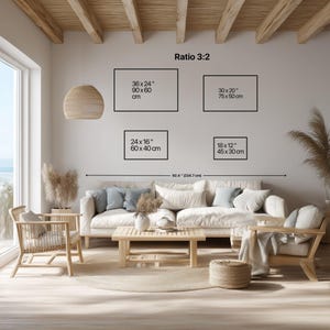 Peut inclure: Int&eacute;rieur de salon lumineux aux tons neutres. Un canap&eacute; blanc est orn&eacute; de coussins, accompagn&eacute; de chaises en bois et d'une table basse. Le mur pr&eacute;sente des &oelig;uvres encadr&eacute;es de dimensions : 90x60cm, 75x50cm, 60x40cm et 45x30cm. La pi&egrave;ce est &eacute;clair&eacute;e par la lumi&egrave;re naturelle.