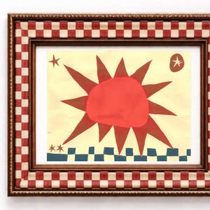 Peut inclure: Une &oelig;uvre d'art encadr&eacute;e avec un motif de soleil rouge vif sur fond cr&egrave;me. L'&oelig;uvre comprend des &eacute;toiles et une bordure &agrave; carreaux bleus et blancs. Le cadre pr&eacute;sente un motif &agrave; carreaux rouges et blancs.