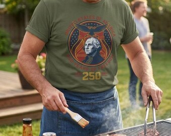 Puede incluir: Una camiseta verde oliva con un gráfico circular que muestra un retrato de George Washington, un águila calva y el texto United States of America 250 Years of Freedom 250 Years. El diseño incluye elementos patrióticos en rojo, blanco y azul.