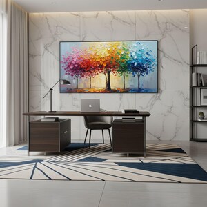 May include: A modern office space featuring a large, colorful tree painting above a dark wood desk. The desk has two matching drawer units, a laptop, and a black chair. A patterned rug and a black bookshelf complete the room.