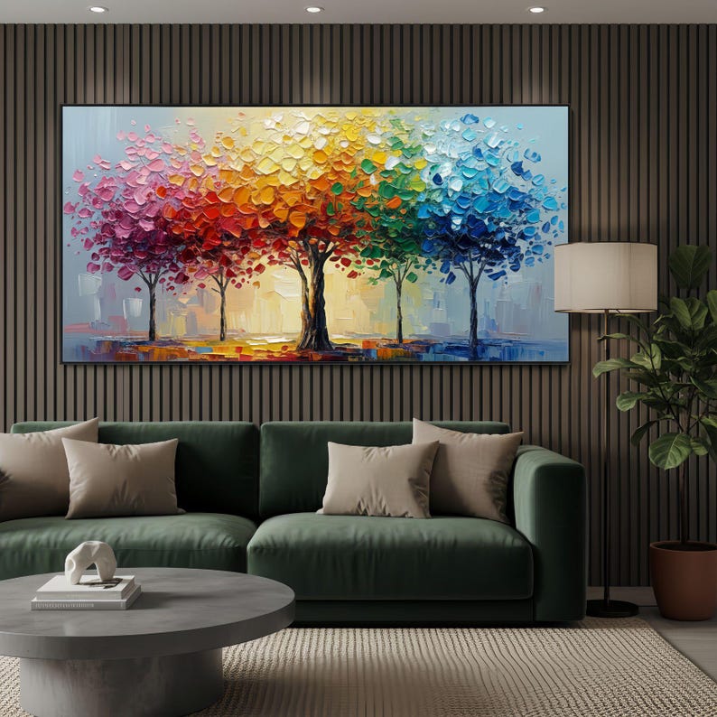 May include: A large, rectangular oil painting depicting a row of trees with vibrant, multicolored foliage. The artwork features a palette of pink, red, orange, yellow, green, and blue, creating a rainbow effect. The painting is displayed above a green sofa.