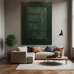 Puede incluir: Una gran pintura abstracta verde oscuro con líneas verticales cuelga sobre un sofá seccional beige. El salón cuenta con una mesa de centro redonda, un pequeño árbol en maceta y cojines decorativos en tonos azules y naranjas. Una lámpara colgante negra cuelga del techo.