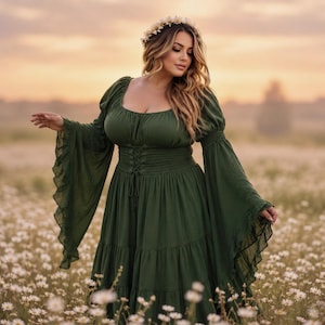 May include: A dark olive green dress featuring a square neckline, long flared bell sleeves with ruffled edges, and a corset-style lace-up bodice with a smocked waist. The dress has a tiered skirt and is worn with a white daisy flower crown.
