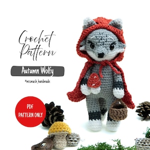 May include: A handmade crochet wolf doll in a red hooded cape, holding a basket. The doll is grey, white, and black, with a red cape and a mushroom accessory. The text "Crochet Pattern" and "Autumn Wolfy" are visible.