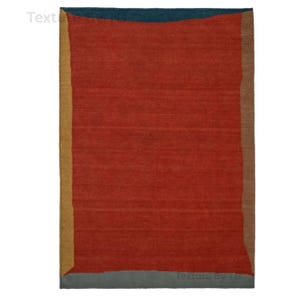 Puede incluir: Una alfombra rectangular con un gran centro rojo, enmarcada por un borde superior turquesa, un borde derecho marrón y un borde izquierdo dorado. El borde inferior es gris. La alfombra tiene una apariencia texturizada.