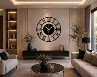 May include: A large circular wall clock featuring a black metal frame with open-work Roman numerals and a solid black center disc. The clock has thin, gold-colored hour and minute hands positioned against the dark background of the dial.