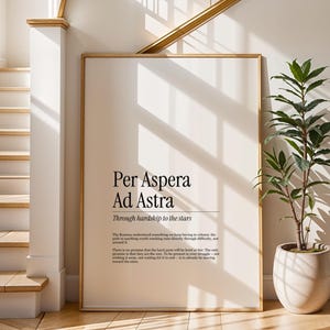 以下が含まれることがあります： モダンなフォントで「Per Aspera Ad Astra」と書かれた額入りのプリントが、明るいインテリアに飾られています。プリントは白い壁に飾られ、階段と鉢植えの植物がインテリアに彩りを添えています。全体的な美しさはミニマリストでエレガントです。