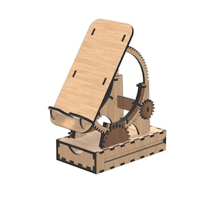 Op de afbeelding: Een houten telefoonstandaard met een tandwielmechanisme. De standaard is gemaakt van lichtbruin hout en heeft een kantelbaar platform, een tandwielsysteem en een kleine lade. Het ontwerp is ingewikkeld en lijkt lasergesneden.