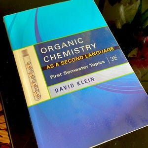 以下が含まれることがあります： デビッド・クライン著「Organic Chemistry as a Second Language」というタイトルの教科書。表紙は、白文字の青とティールのグラデーションデザインです。試験管の図が表紙の左側にあります。